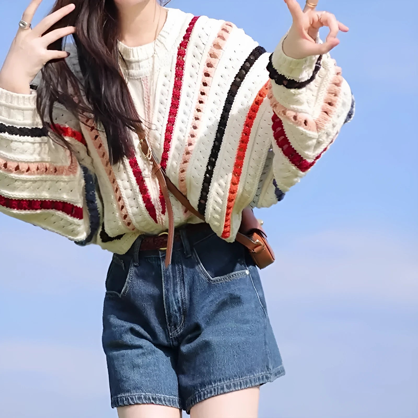 Round neck pullover sweater with rainbow stripes in hollow knit design featuring batwing sleeves
