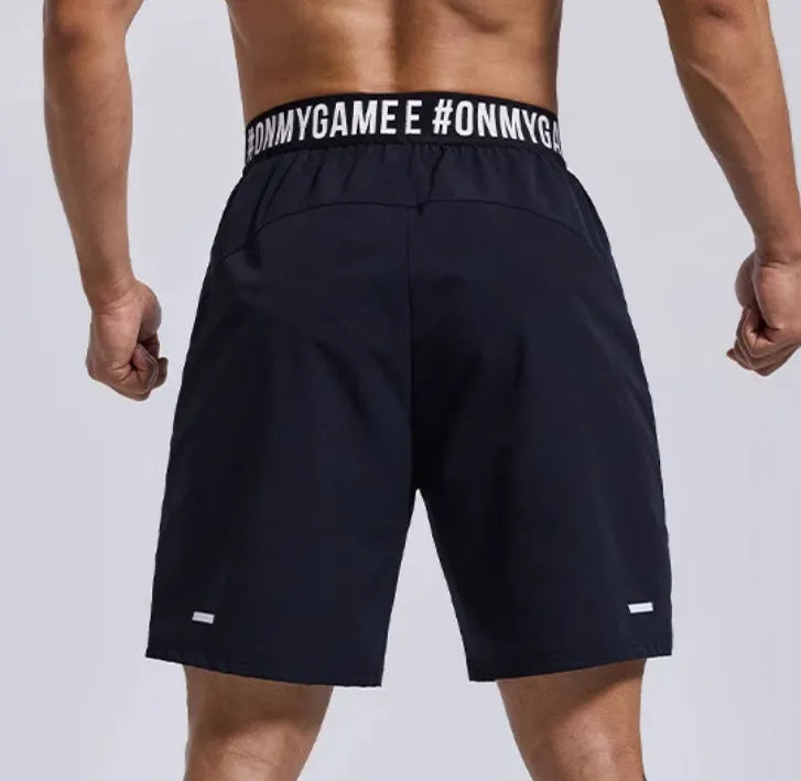 Men's black loose fit cropped workout shorts with elastic waistband and letter detailing