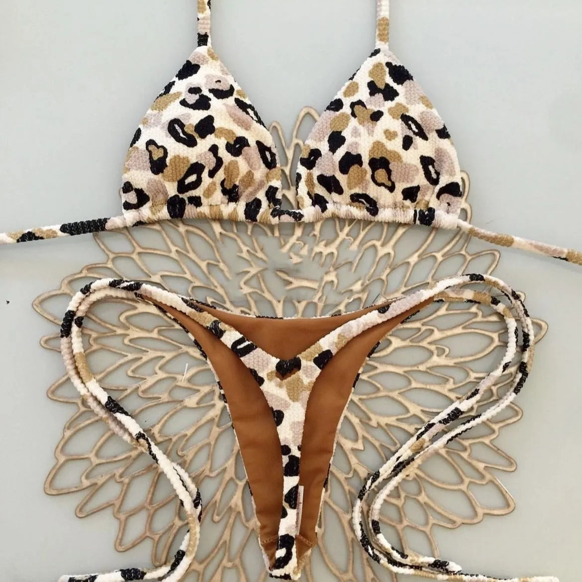 Women's printed bikini swimsuit set on a hanger, showing quick-dry fabric and cotton-lined briefs.