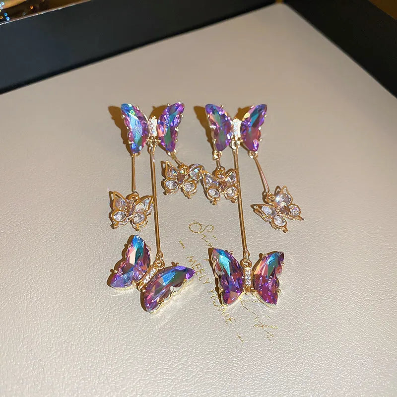 Silver needle blue purple butterfly tassel drop earrings with crystal flower details on alloy.