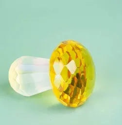 Colourful geometric crystal mushroom decoration on a white background.