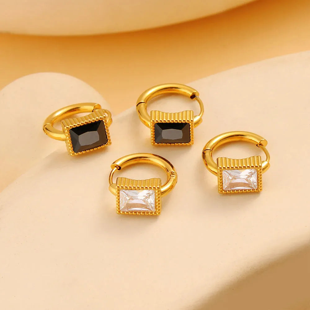 Square geometric stainless steel earrings with round ring details in white, black, or green electroplated finish.