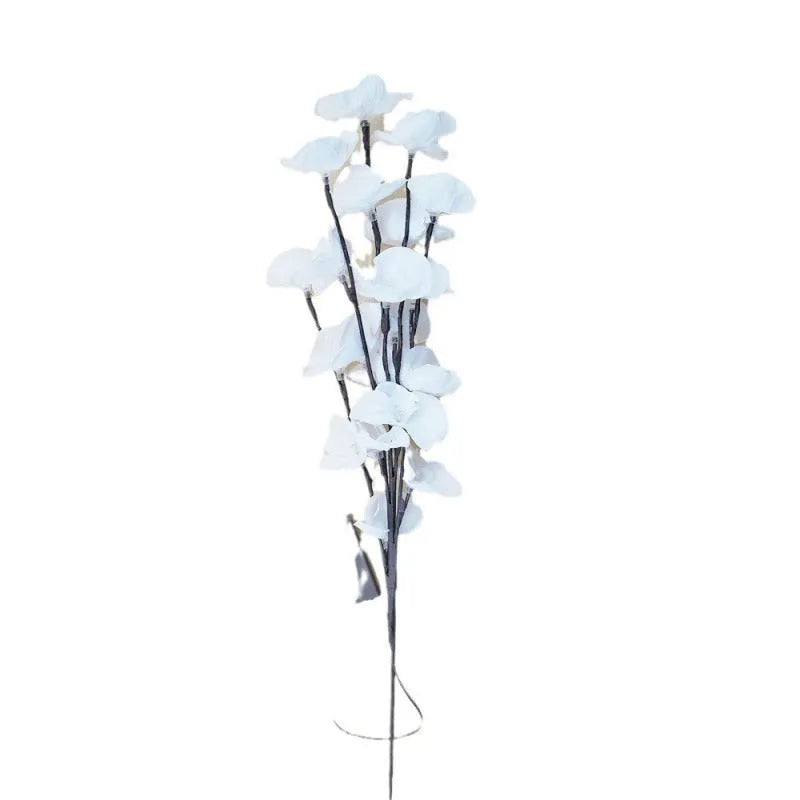 Pink LED phalaenopsis orchid branch decorative light on a table, 65cm long with warm white lights.