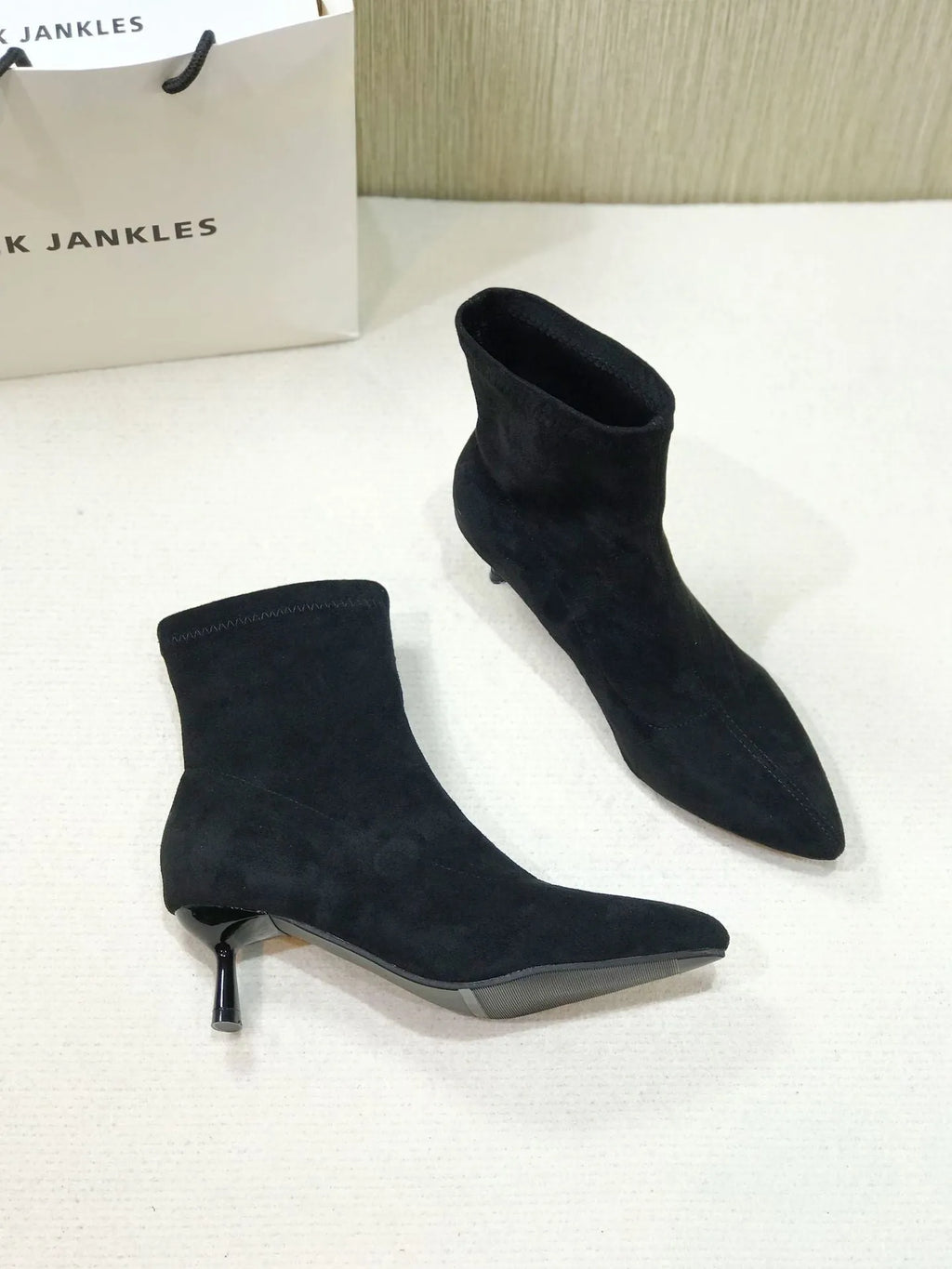 Women's black pointed toe ankle boots with stiletto heel and mid-calf length