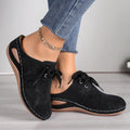 Women's black lace-up baotou slippers with a suede upper and rubber sole on a neutral background.
