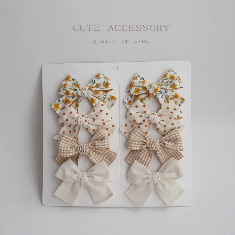 Set of children's cloth hair clips with a dovetail bow design in various colours.