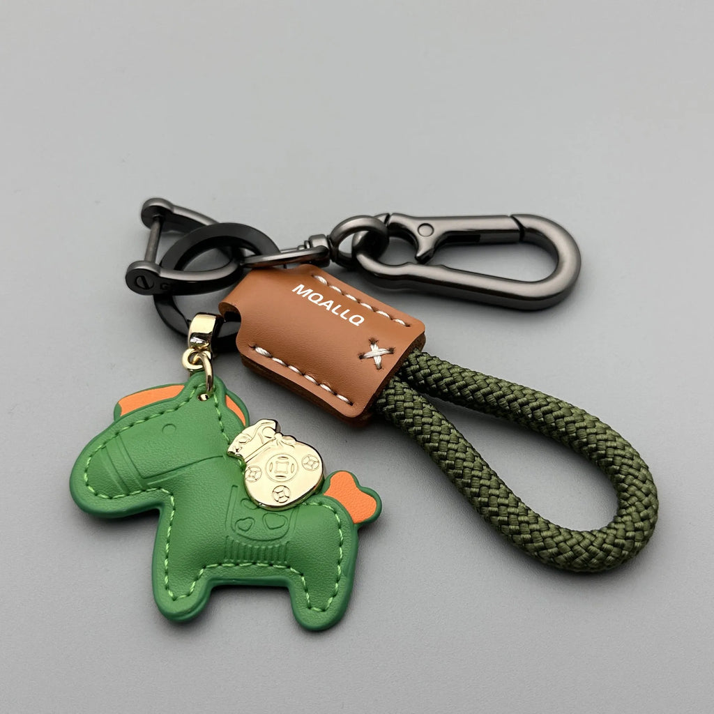 Handmade brown cowhide leather key ring with a gold-toned zinc alloy pony buckle and a green plaited flannelette rope.