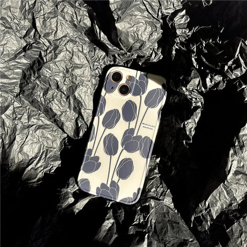 Black silicone iPhone case featuring a printed tulip flower design on the back.