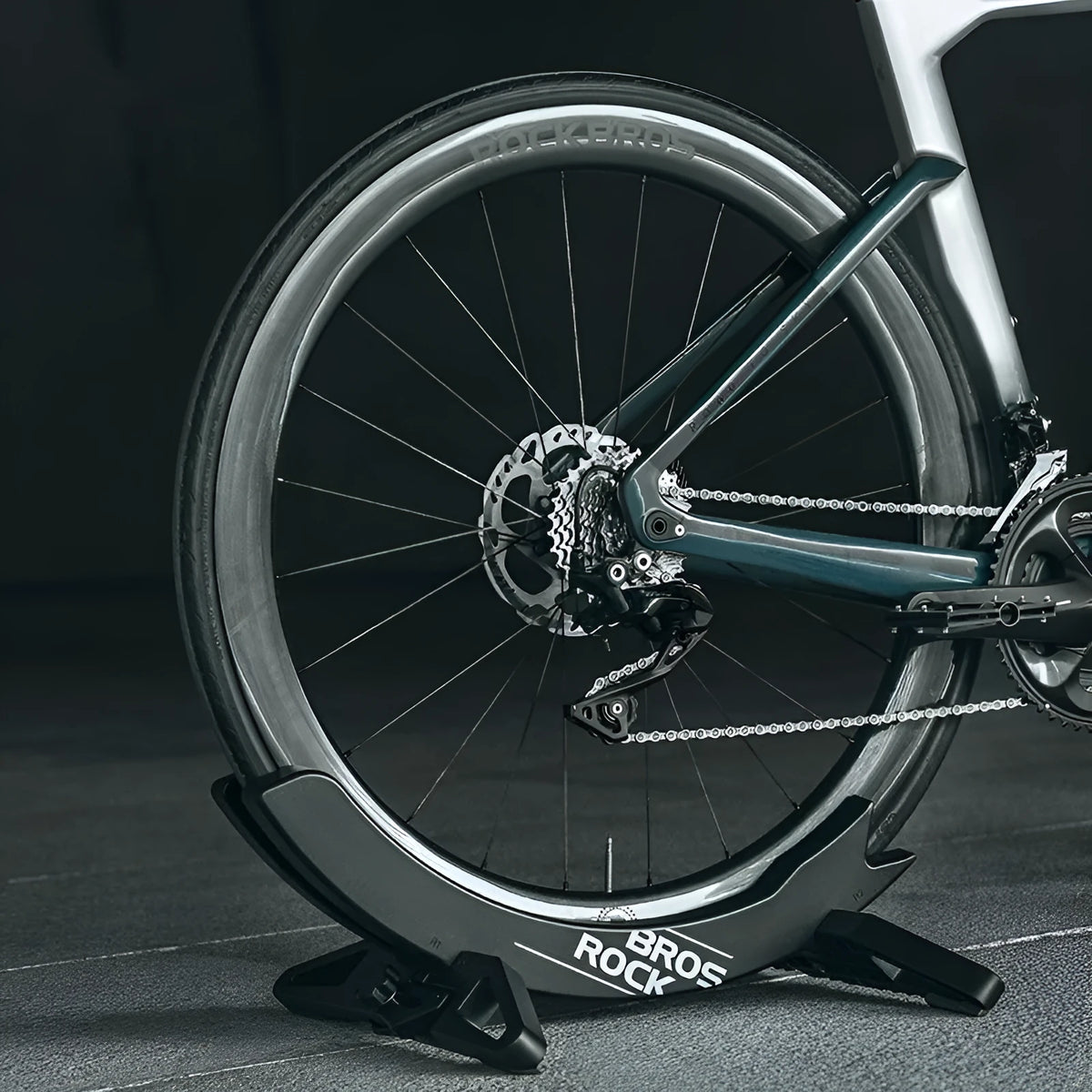 Black and green ABS plastic bicycle parking rack holder mounted on a wall.