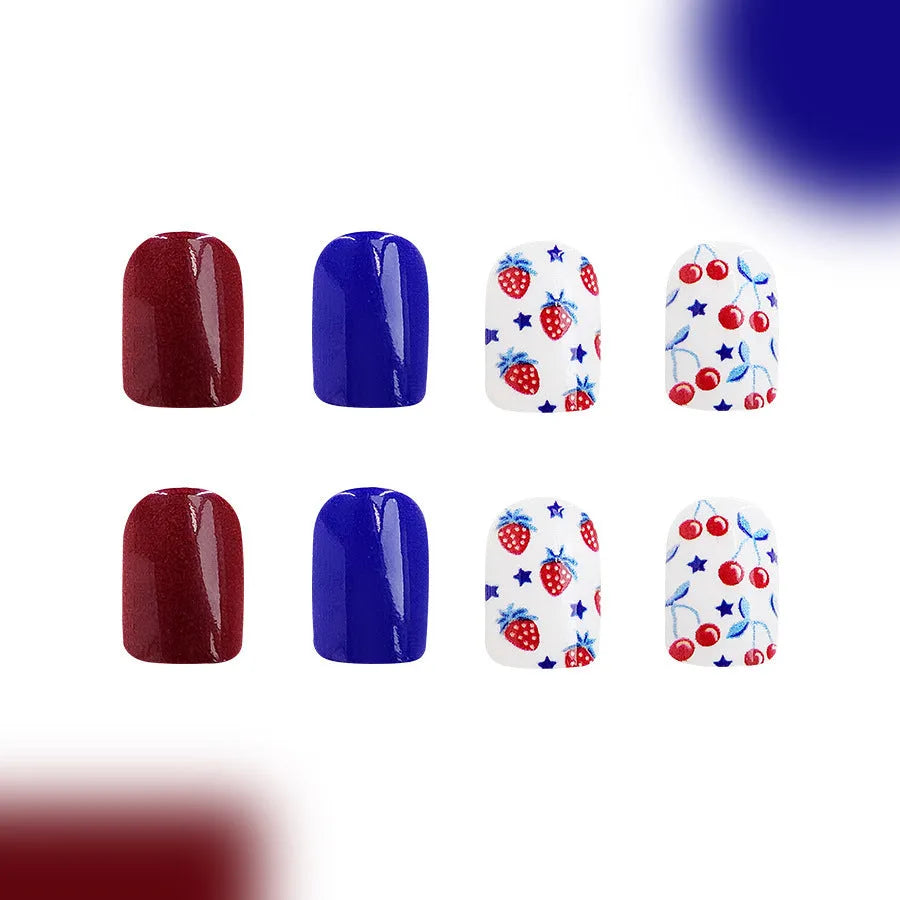Short glossy red and blue strawberry cherry pattern false nail stickers laid out.