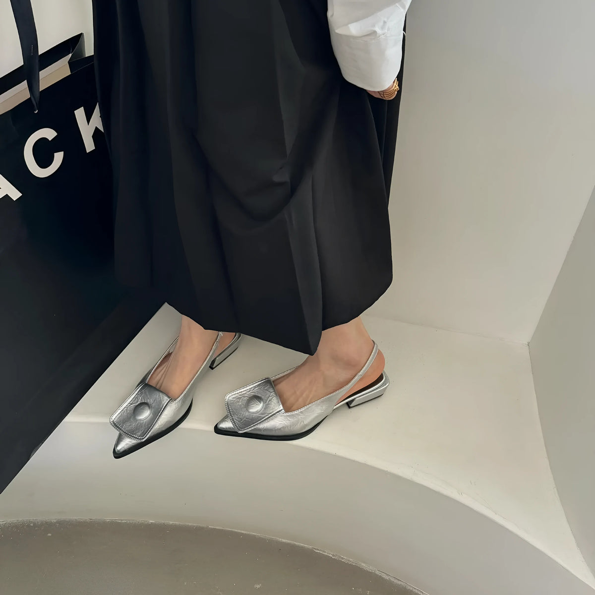 Women's low-heel pointed toe sandals with a back strap in apricot colour on a white background.