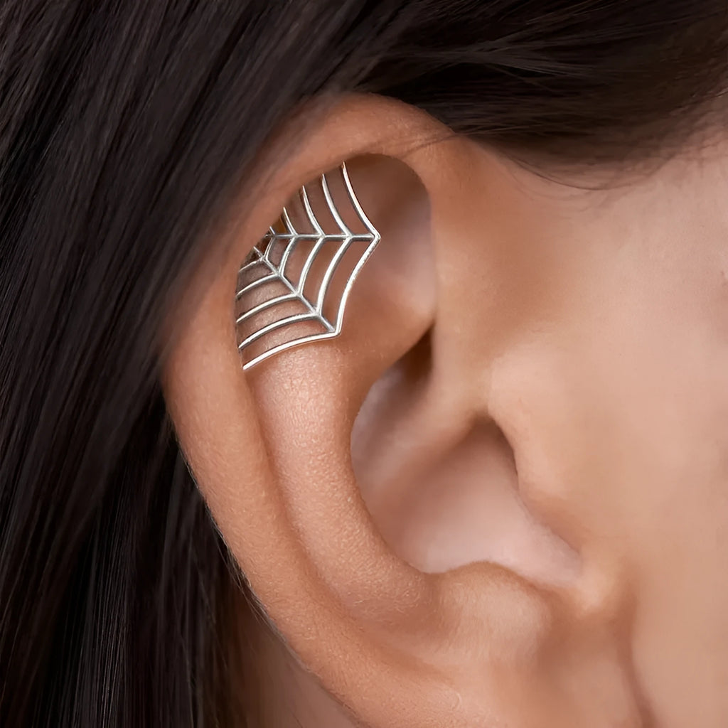 Close-up of metal spider web geometric mesh design stud earrings in a gold electroplated finish.