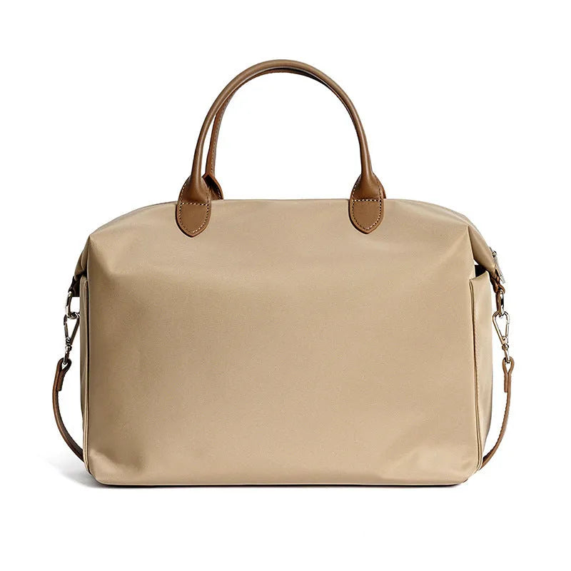 Black nylon waterproof shoulder bag with leather handbag detail and large main compartment.