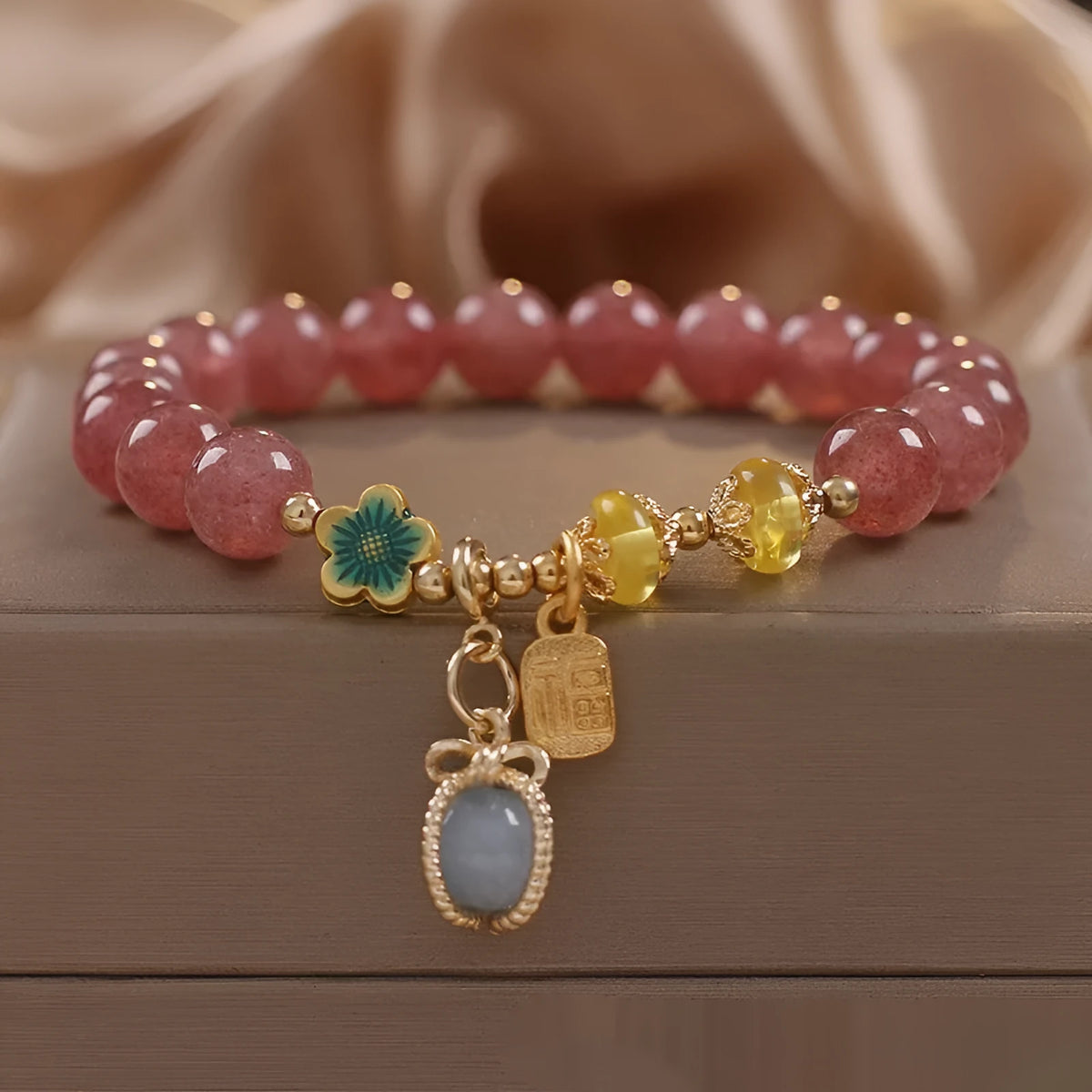 Red women's bracelet with strawberry quartz beads, alloy metal elements, and rhinestone decorative details on adjustable band