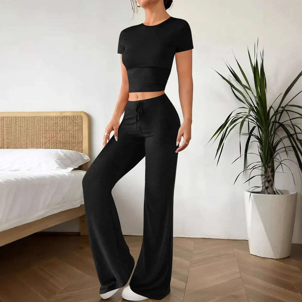 Black women's high waist trousers and short sleeve top coordinated suit set on a hanger.