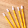 Pack of multi-coloured disposable lip brushes with soft flocked heads on a black handle.