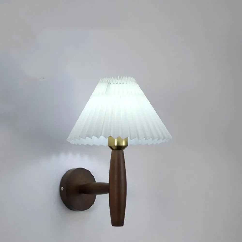 American Retro style wooden wall lamp with copper accents and a white fabric shade mounted above a bedside table.