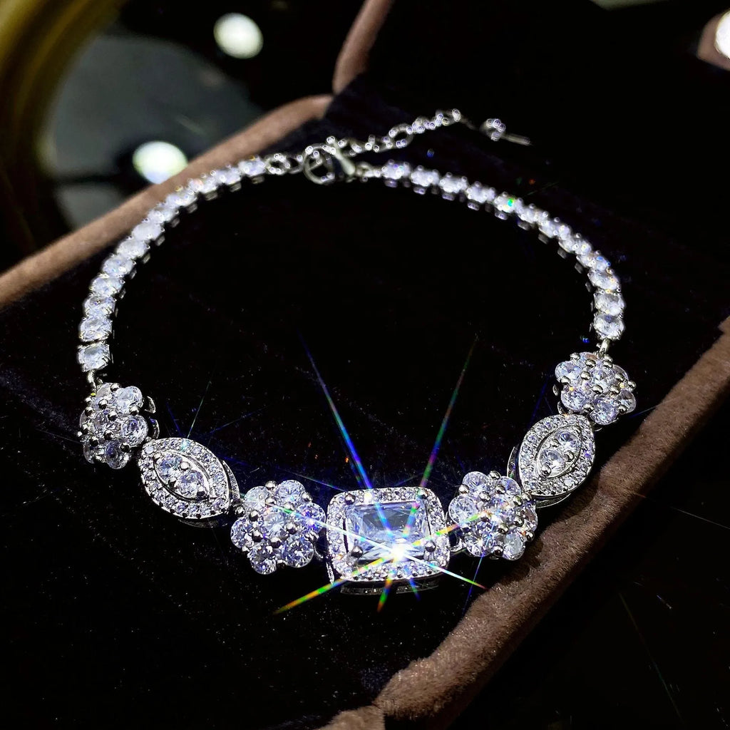 Women's geometric silver and white gold plated bracelet with inlaid zircon stones on a model's wrist.