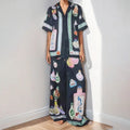 Women's black polyester co-ord set with cartoon animation print showing cardigan and trousers