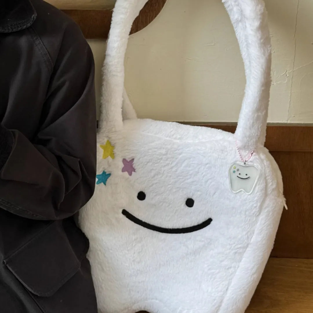 White plush tote bag with a cute teeth pattern, showing the shoulder strap and zipper closure