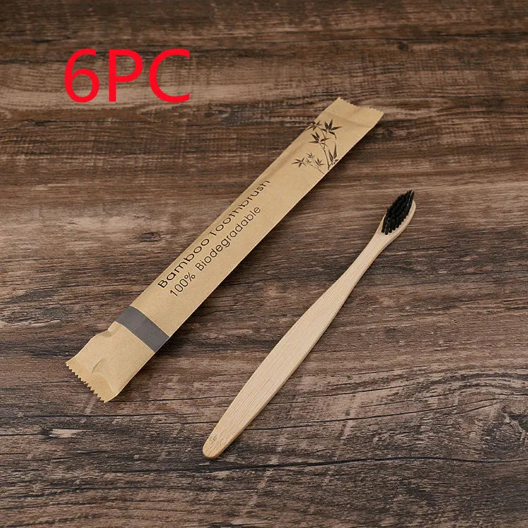 Ten bamboo toothbrushes with coloured handles and charcoal bristles laid out side by side.