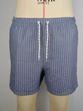 Man or woman wearing striped polyester shorts in navy blue, straight leg style, for beachwear.
