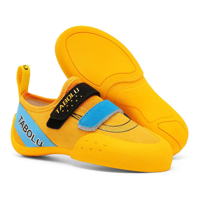 Beginner rock climbing shoes in black and red with Velcro strap and rubber sole.