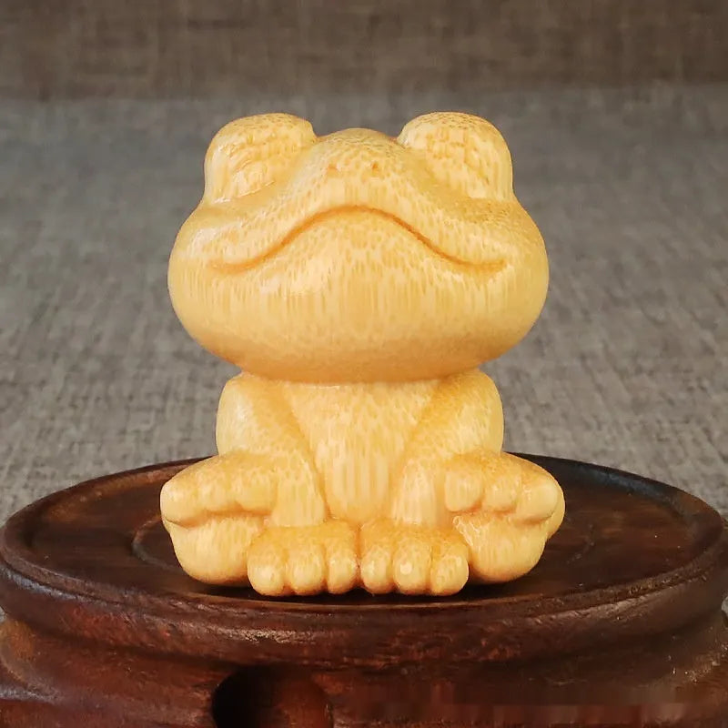 Solid bamboo carving ornament of a smiling frog cartoon character.