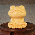 Solid bamboo carving ornament of a smiling frog cartoon character.