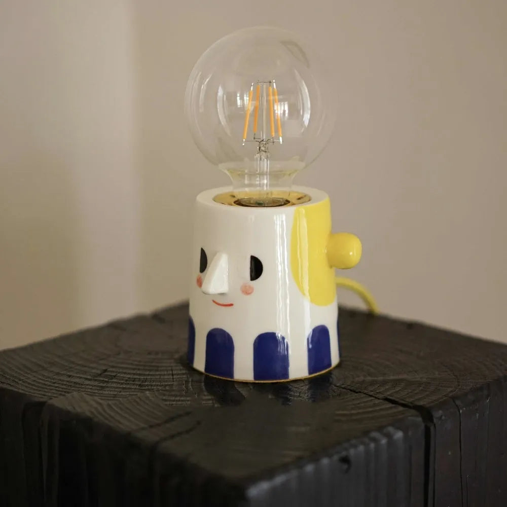 Handmade ceramic table lamp with ball-shaped shade on wooden surface