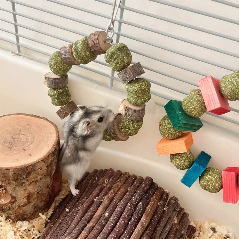 Small pet chew toy showing a ring with a decorative straw ball, in either sequin or applewood style.