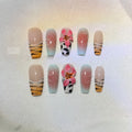 Hand-carved zebra pattern and lily design nail art pieces in four sizes on a clear background.