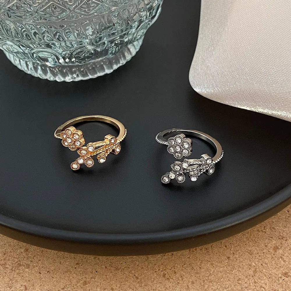 Close-up of a women's open ring with detailed floral leaf engraving, shown in gold colour finish.