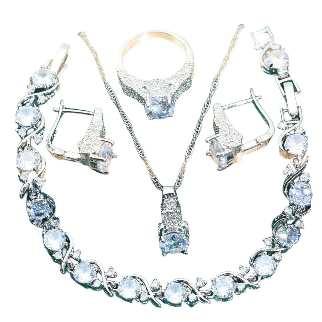 Four-piece bridal jewellery set showing alloy pendant necklace, bracelet, earrings, and ring on a white background.