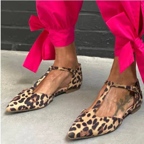 Women's leopard print pumps with a pointed toe, low chunky heel, and a cross shoulder strap.