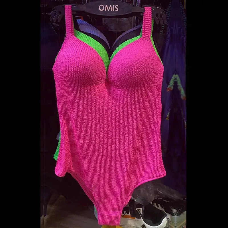 Women's black one-piece swimsuit with a sunken stripe pattern, shown on a mannequin.