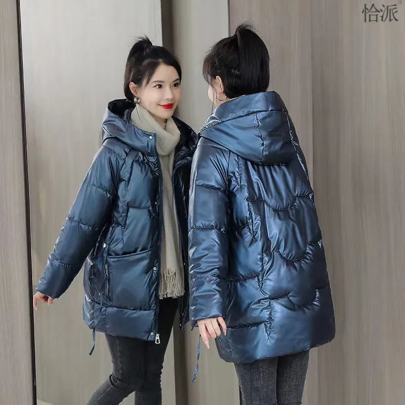 Women's green thick loose fit hooded winter jacket with long sleeves on a hanger.