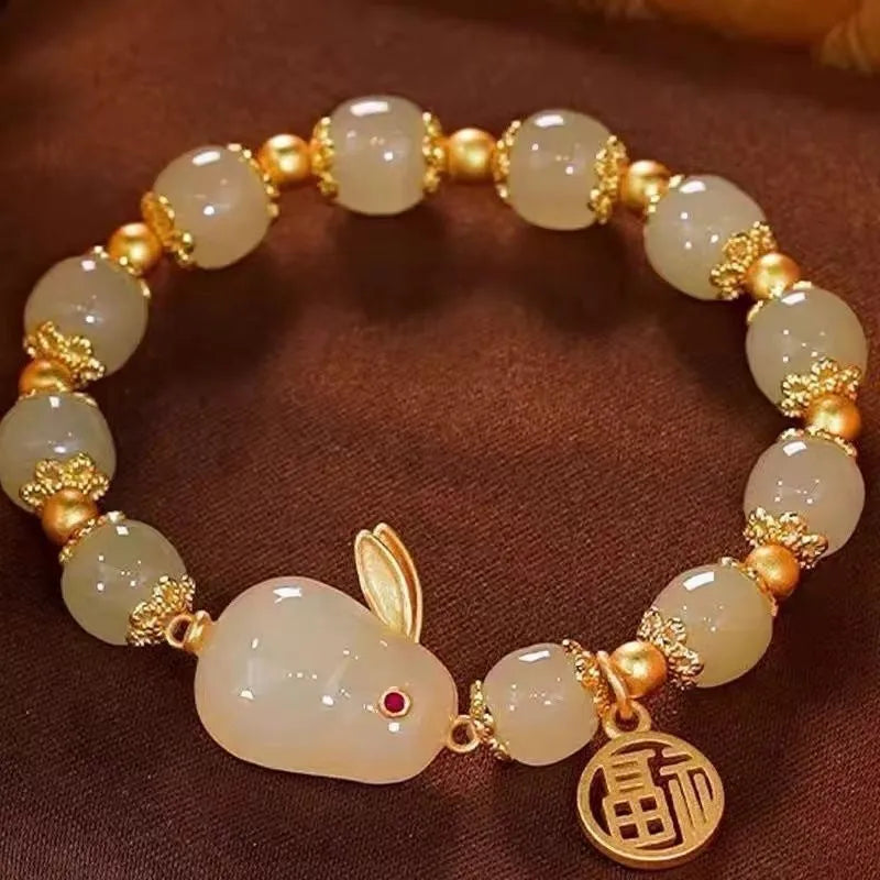 Women's green jade bracelet with black hand charm and hare pendant featuring fu character and lily motifs