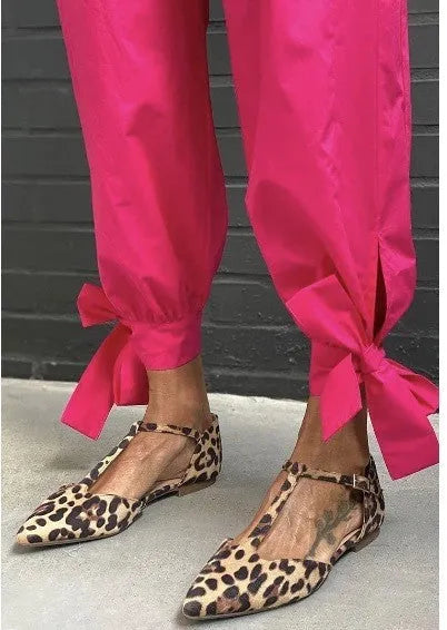 Women's leopard print pumps with a pointed toe, low chunky heel, and a cross shoulder strap.