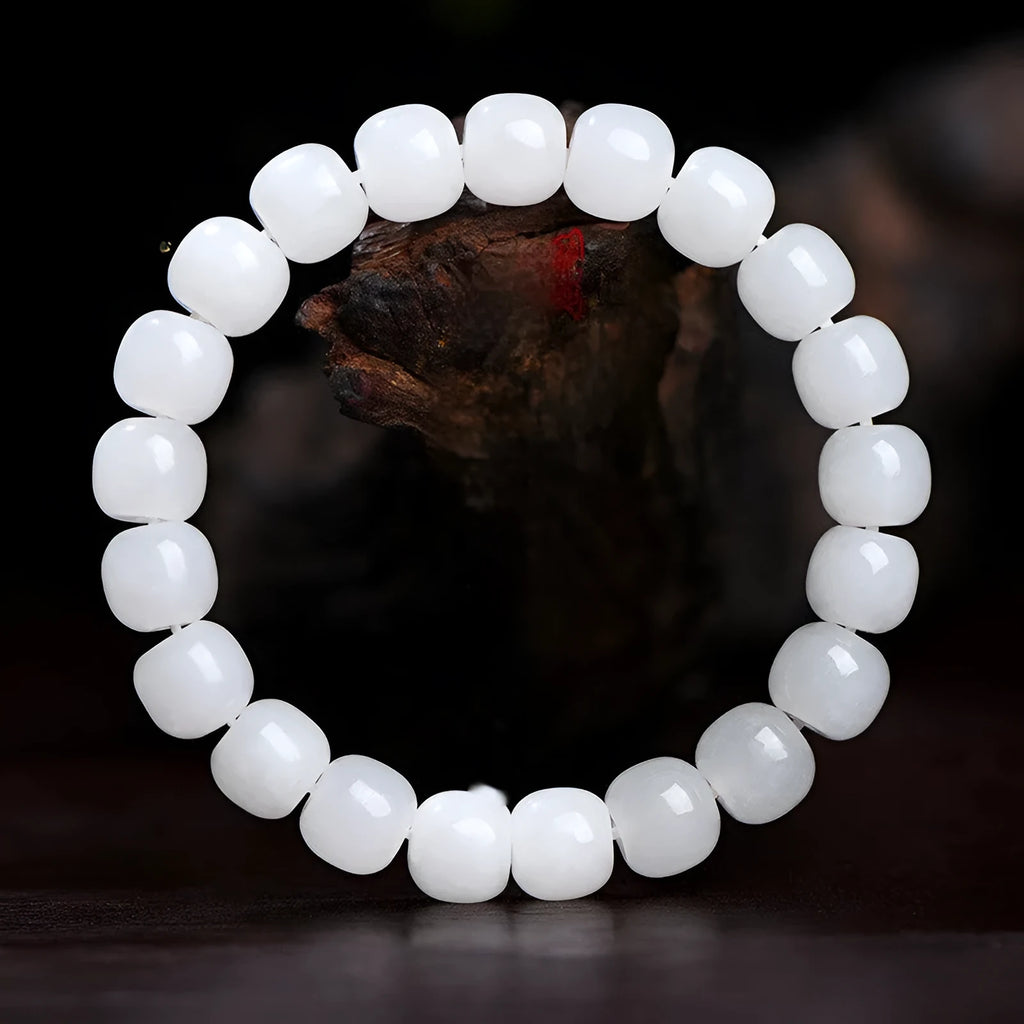 White Hetian jade barrel bead bracelet on a wrist, showing three bead size options.