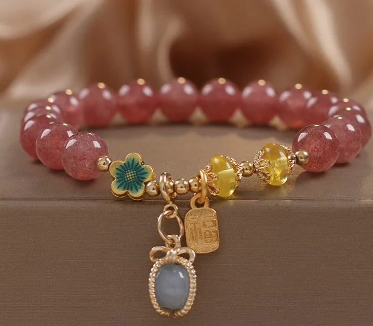 Red women's bracelet with strawberry quartz beads, alloy metal elements, and rhinestone decorative details on adjustable band