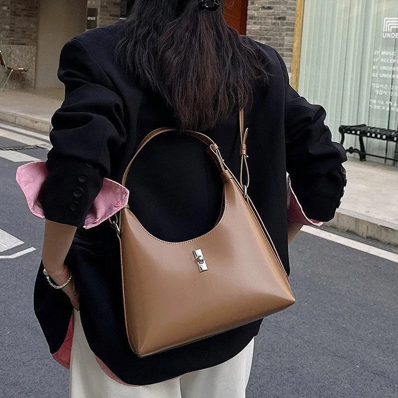 Soft genuine leather dumpling-shaped crossbody bag in apricot with sewing thread detail.