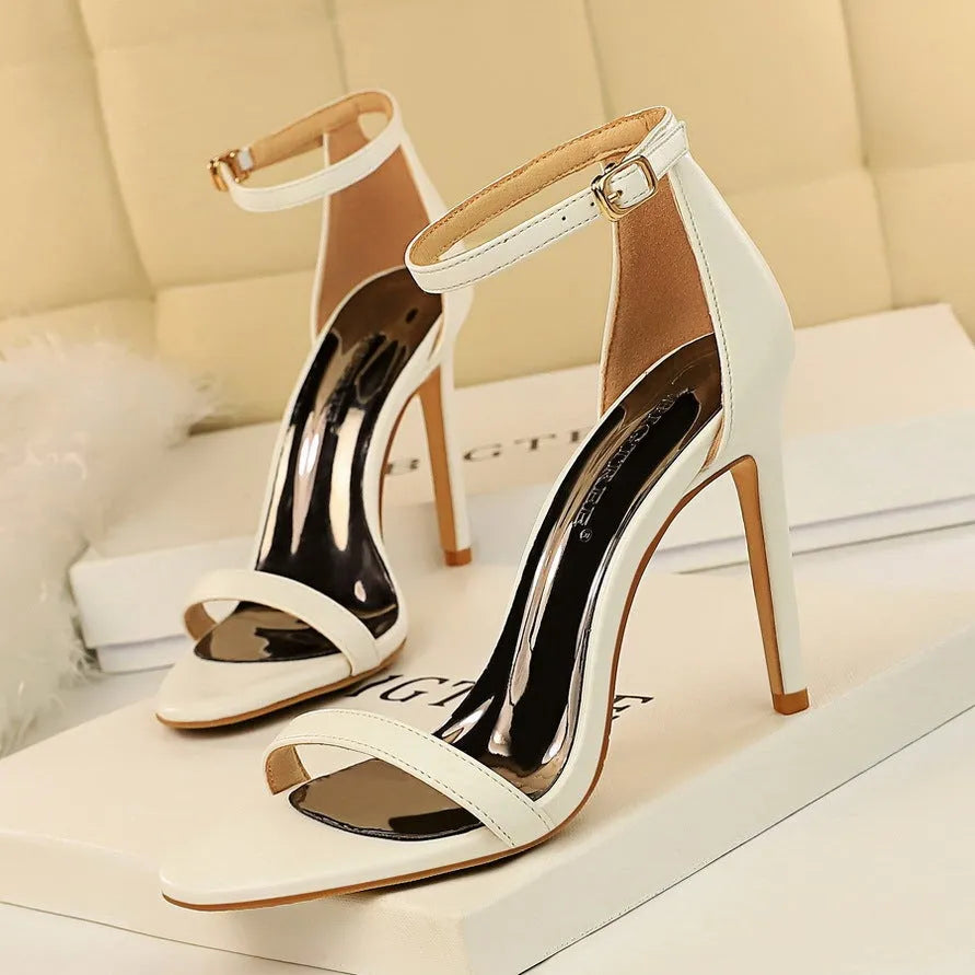 Women's open toe high heels with an ankle strap and buckle, in a choice of six colours including red, black, and white.