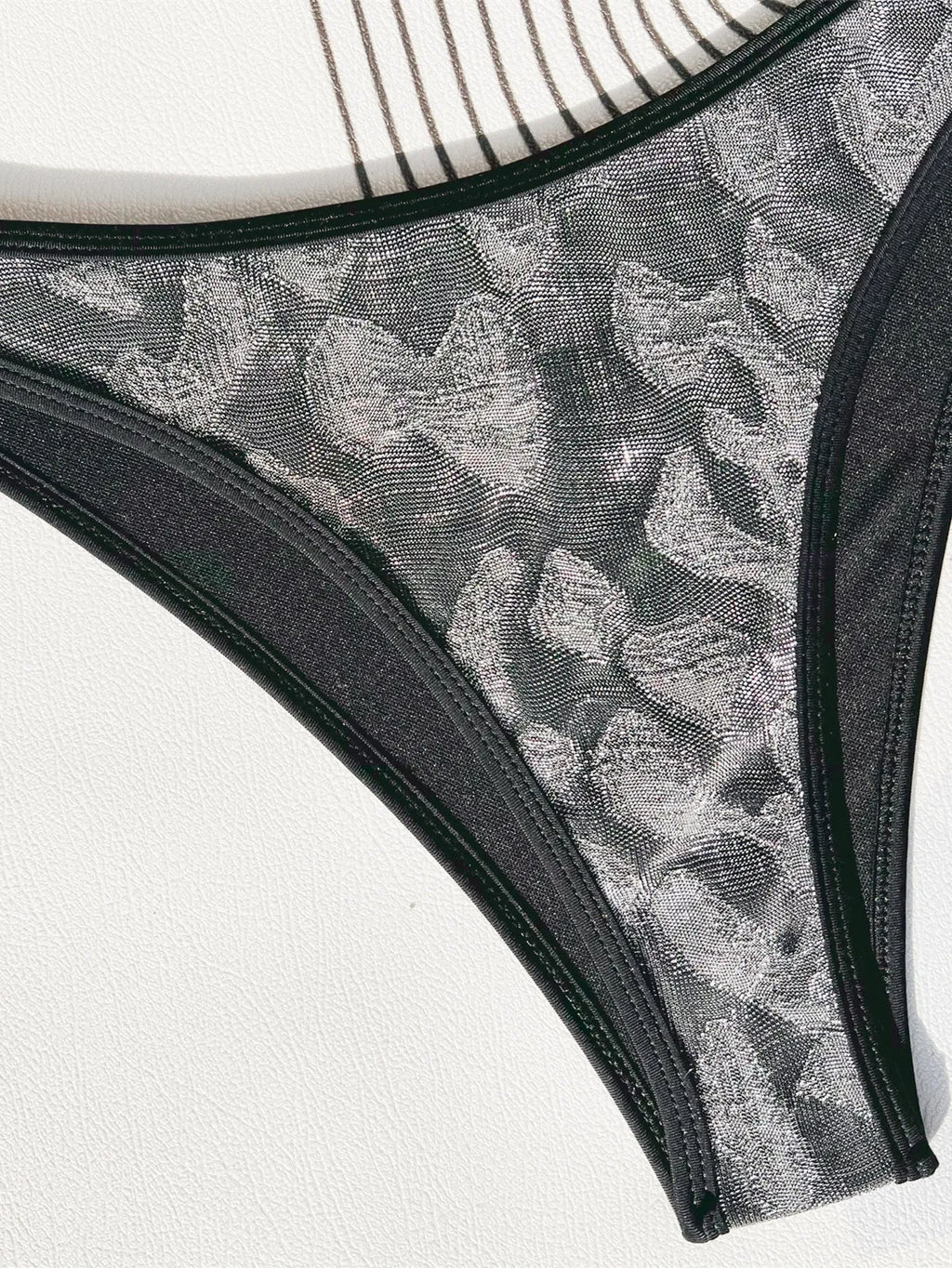 Ladies black polyester bikini swimsuit with strap design on a mannequin.