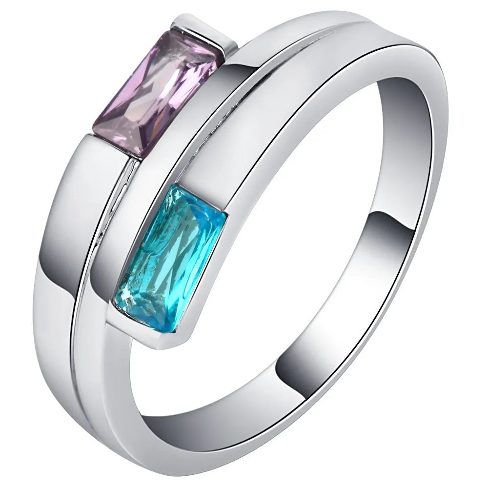 Copper ring with inlaid zircon stone in electroplated silver finish on a grey background.