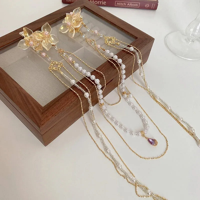 Gold-coloured women's hairpin with a pearl diamond flower decoration and a long acrylic tassel.