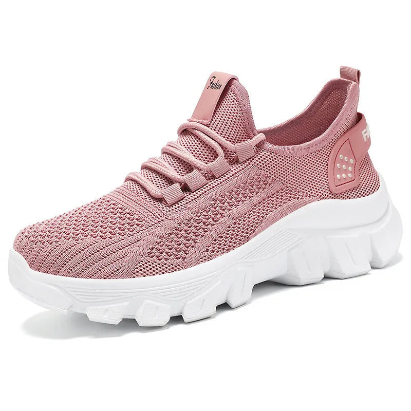 Women's white Flyknit sneaker with thick PVC sole and lace-up closure on a neutral background.