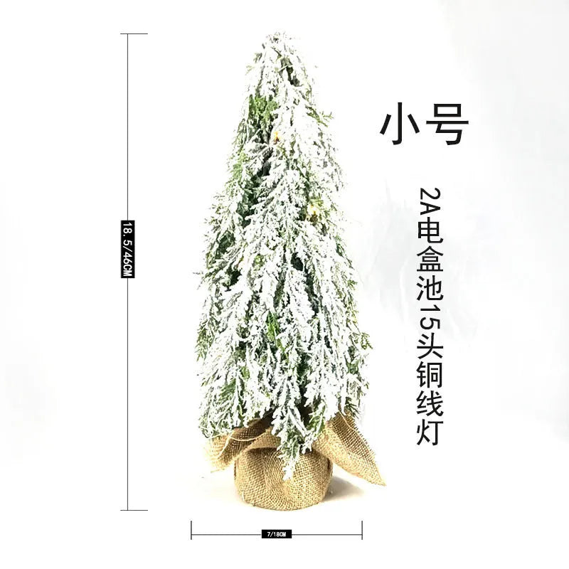 Small 24-inch artificial Christmas tree with LED lights and snow sprayer ornament on desktop