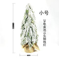 Small 24-inch artificial Christmas tree with LED lights and snow sprayer ornament on desktop