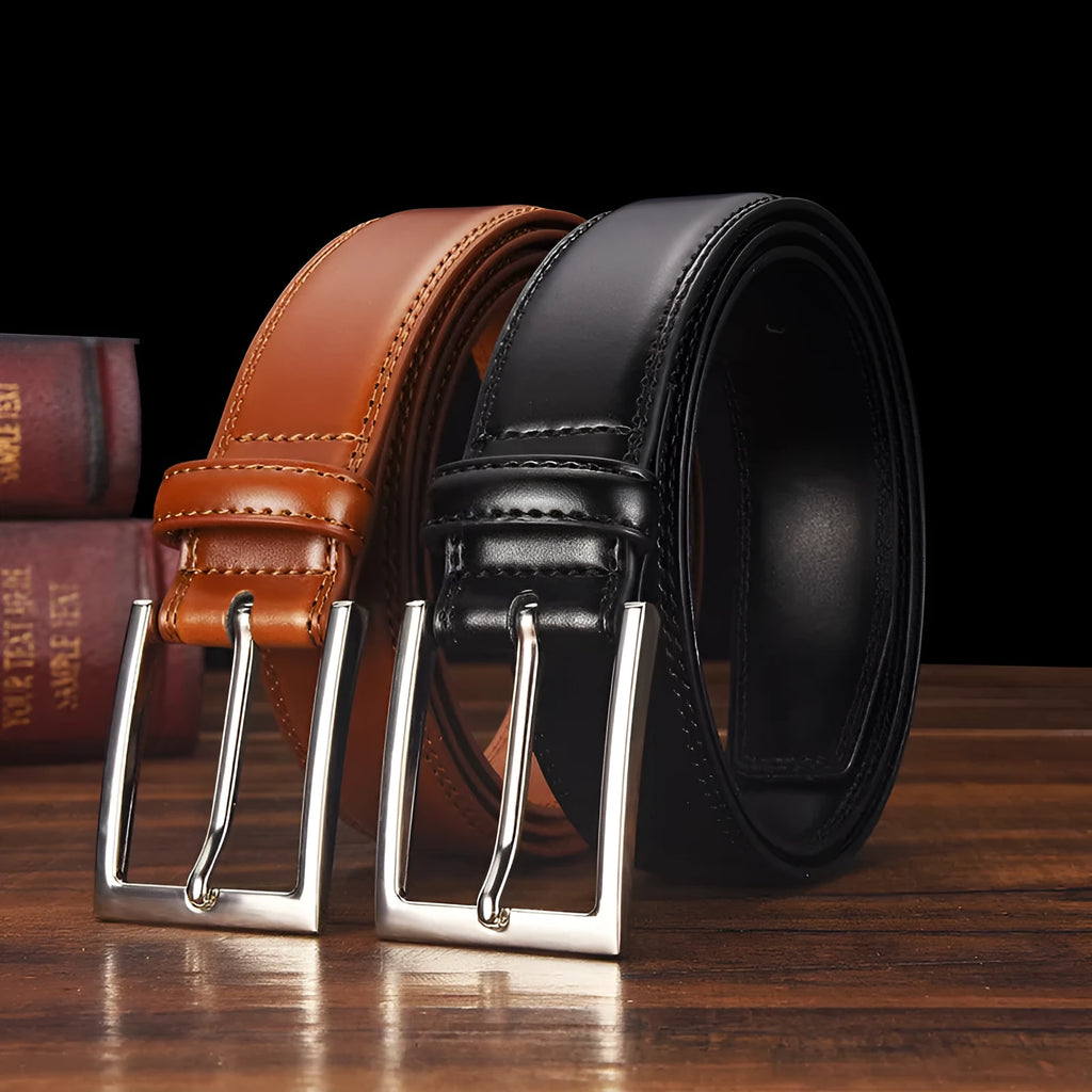 Men's black leather belt with a silver alloy pin buckle on a wooden background.